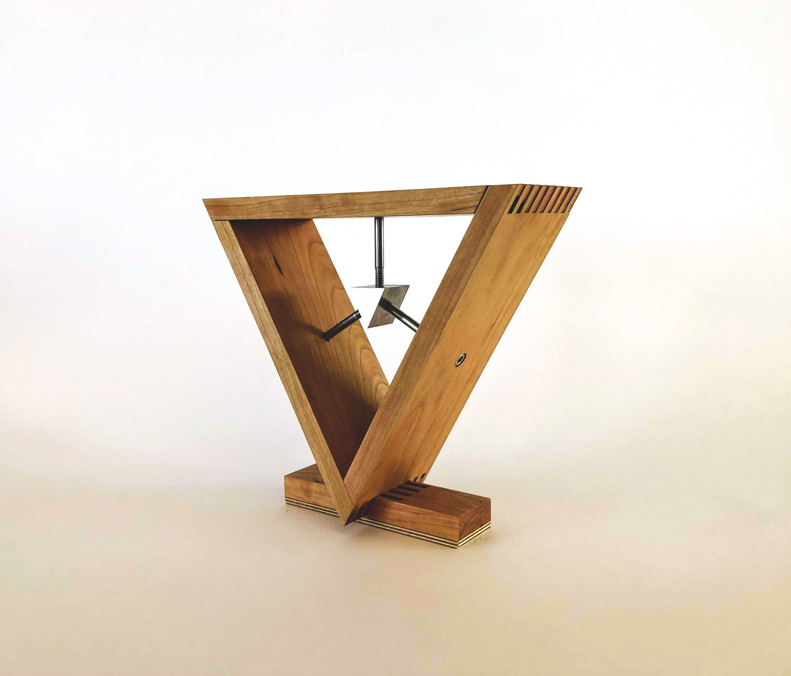 Wooden triangular sculpture with a suspended metal prism